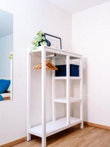 a white shelf in a room with a mirror at La Suite Cosy in Roppenheim