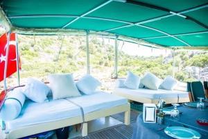 un bateau avec 2 lits et un toit vert dans l'établissement Derin Tekne, à Göcek