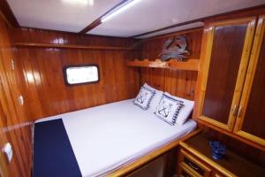 um pequeno barco com uma cama na parte de trás em Derin Tekne em Göcek