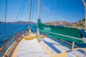 a boat with a green sail on the water at Derin Tekne in Göcek