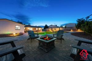 un patio trasero con una hoguera y dos bancos en Casa De Paradise Hills, en Albuquerque