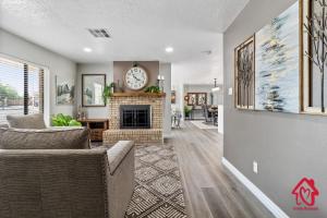 sala de estar con chimenea y reloj en la pared en Casa De Paradise Hills, en Albuquerque