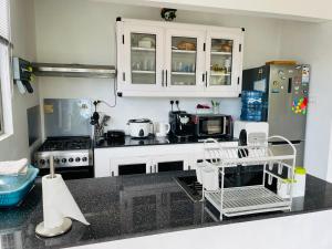 a kitchen with white cabinets and a black counter top at Maison Stacie in Chemin Grenier