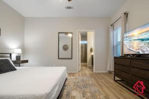 1 dormitorio con 1 cama, vestidor y TV en Petroglyph Place - An Irvie Home, en Albuquerque