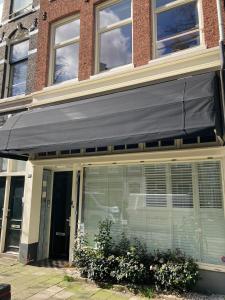 a black awning on the front of a building at LIEV Amsterdam Cozy boutique suite in The Pijp in Amsterdam