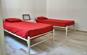 - 2 lits avec des couvertures rouges dans une chambre dans l'établissement TARRAFAL SN TOUR, à Tarrafal
