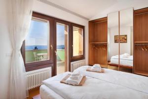 a bedroom with two beds and a large window at REGINA GARDESANA in Garda