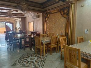 a dining room with wooden tables and chairs and a room with at 利人市 in Madinaty