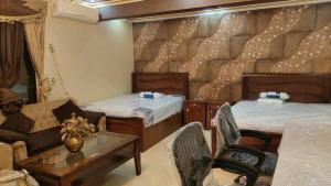 a room with two beds and a couch and a table at 利人市 in Madinaty