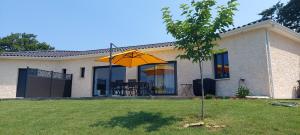 ein gelber Regenschirm vor einem Haus in der Unterkunft Gite du chêne vert - Périgord in Salignac Eyvigues