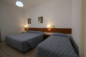 una camera d'albergo con due letti e due lampade di Hotel Península ad Avaré