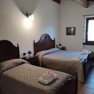 a hotel room with two beds with towels on the bed at Il Casale della Biodiversità in Scanzano