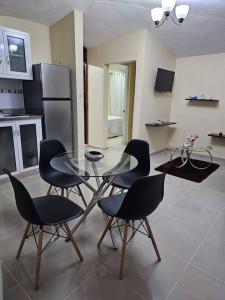 a kitchen with a glass table and four chairs at hermoso apartamento céntrico in San Felipe de Puerto Plata