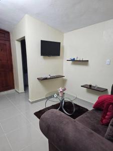 a living room with a couch and a tv on a wall at hermoso apartamento céntrico in San Felipe de Puerto Plata