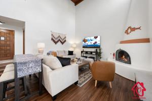 uma sala de estar com um sofá, uma mesa e uma lareira em Pueblo Moon w Pool - An Irvie Home em Alameda