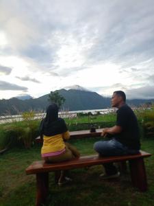 a man and a woman sitting on a bench at Volcano Cabins in Kubupenlokan