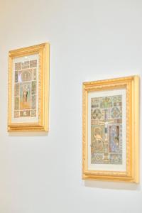 deux tableaux encadrés sur un mur blanc dans l'établissement OKRA Apartment Pescara Centro, à Pescara