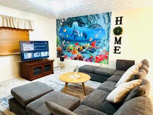 een woonkamer met een bank en een televisie bij Ocean Palace -12 Guests- close to I-75-Amazing Location!! in Maud
