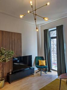 卡爾斯魯厄的住宿－Zen Apartment - 2 bedrooms - kitchen，客厅配有大电视和椅子