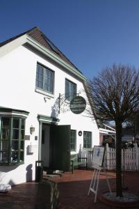 a white building with a sign in front of it at Hotel Witthus GmbH & CoKG in Greetsiel