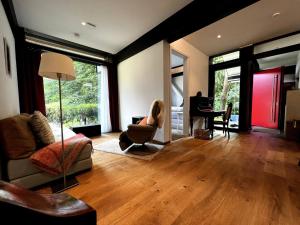 a living room with a couch and a chair and a piano at New exclusive 2 bedroom apartment Hamburg in Hamburg