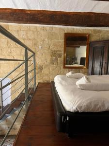 two beds in a room with a mirror at Valletta Period Townhouse in Valletta