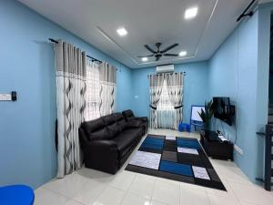 Pokok Sena的住宿－Homestay Sejahtera，客厅配有黑色真皮沙发和蓝色的墙壁