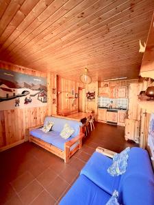 sala de estar con 2 sofás azules y cocina en Dolcevita house in Camigliatello, en Camigliatello Silano