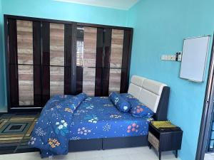 Pokok Sena的住宿－Homestay Sejahtera，一间卧室配有一张蓝色墙壁的床和一扇窗户