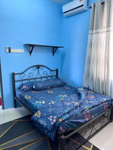 Pokok Sena的住宿－Homestay Sejahtera，蓝色墙壁间的一张床位