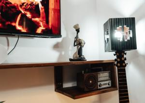 a shelf with a tv and a radio and a lamp at Cozy 2 bedroom with Gym in Dar es Salaam