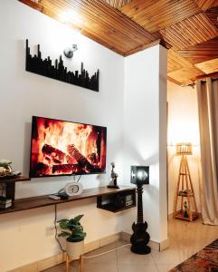 uma sala de estar com uma televisão de ecrã plano na parede em Cozy 2 bedroom with Gym em Dar es Salaam