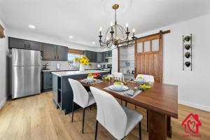a kitchen and dining room with a wooden table and white chairs at ValleyVibe: Modern Comfort in North Valley - an Irvie Home in Albuquerque