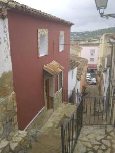 Chella的住宿－Ca'l Suecà，镇上一座红色的房子,有楼梯
