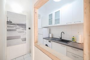uma cozinha com armários brancos e um lavatório em Apartment Floresita em Zadar
