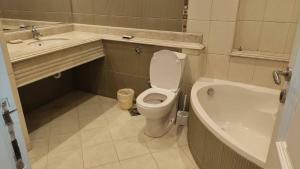 a bathroom with a toilet and a sink and a tub at 利人市 in Madinaty