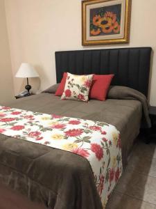 a bedroom with a bed with a floral comforter at Hotel Formigas na Figueira in Tibagi