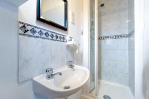 een badkamer met een wastafel, een douche en een spiegel bij Lakeside homestay fast Internet free parking in Londen