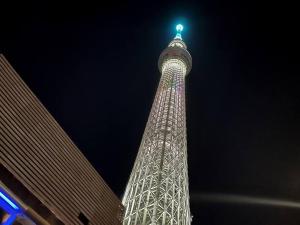 a tall tower with lights on it at night at SKY GATEスカイツリー徒歩3分の貸切ヴィラ/成田羽田直通/浅草徒歩15分 in Tokyo