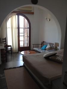 a bedroom with a bed and an arched doorway at Dilina Guesthouse in Agios Nikolaos