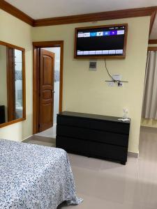 a bedroom with a bed and a tv on the wall at ApartaHotel El Bonao in Higuey