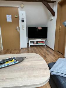 a living room with a table and a tv at Ferienwohnung Brockenblick in Wernigerode