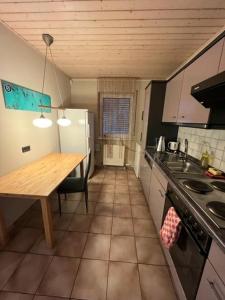 una piccola cucina con tavolo e frigorifero di Soho Ferienwohnung a Rodenbach