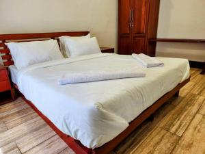 - un grand lit avec 2 serviettes dans l'établissement Cozy 2 bedroom in Moshi Town, à Moshi