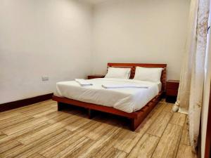 - un lit avec des draps et des oreillers blancs dans l'établissement Cozy 2 bedroom in Moshi Town, à Moshi