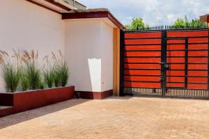 un portail noir et orange avec des plantes en pot dans l'établissement Cozy 2 bedroom in Moshi Town, à Moshi