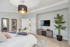 un soggiorno con letto bianco e TV di 5BR 3BA Home - King Beds - Fast Wifi home a Victorville
