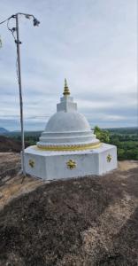 a small white temple on top of a hill at Charitha Rest in Ampara