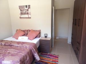 a bedroom with a bed and a dresser and a door at TALITHA'S SELF-CATERING ACCOMMODATION in Walvis Bay