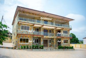 a building that is under construction on a street at B's Classic and Cozy Apartments in Cape Coast